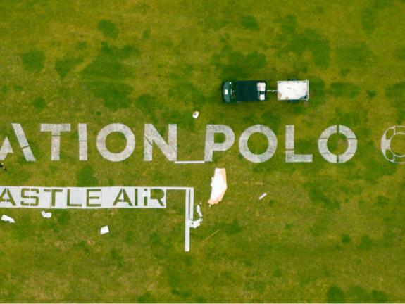 Overhead view of Aviation Polo Cup logo stencilled on grass