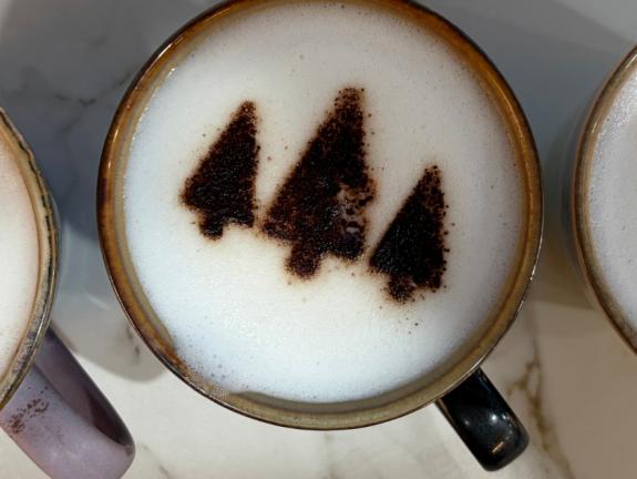 Three coffees with stars, trees and reindeer designs