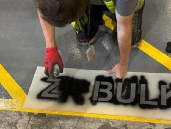 ZR BULK stencil being applied on the floor of an aviation hanger
