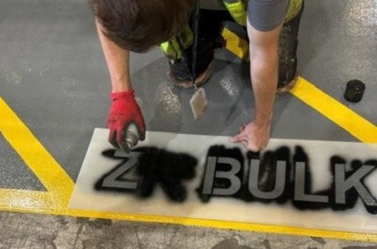 ZR BULK stencil being applied on the floor of an aviation hanger