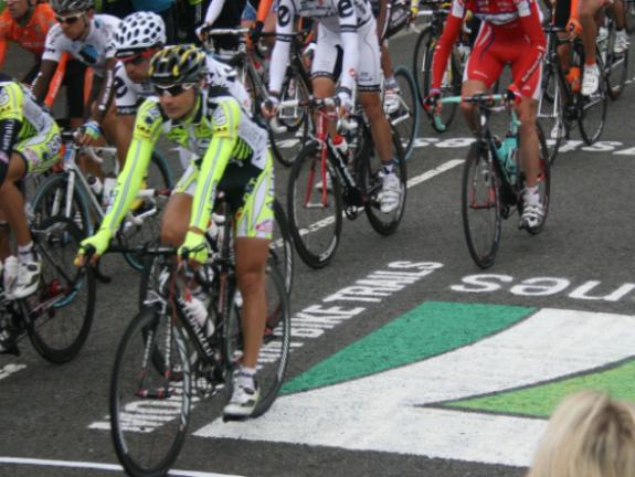 Road cyclists passing over the 7 Stanes logo applied to the road using large stencils