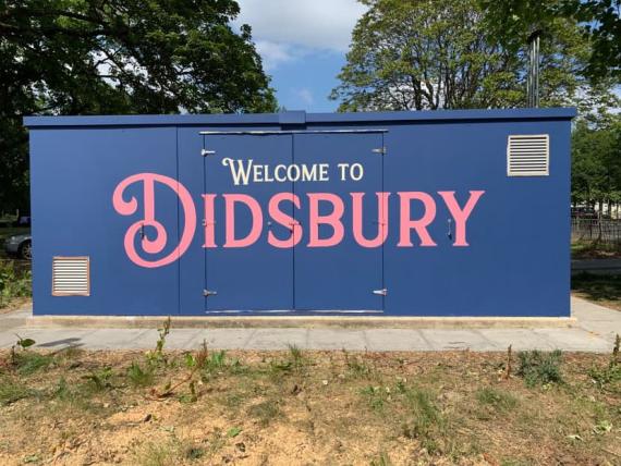 Welcome to Didsbury stencilled on a roadside container