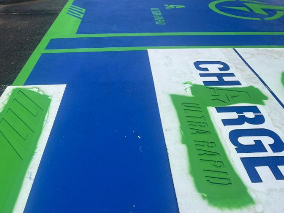 Ground making stencils being applied for electric vehicle charging bays 