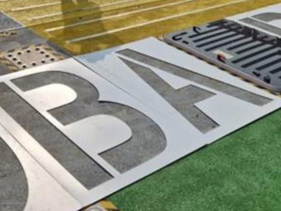 Letters being applied with stencils and a paint roller