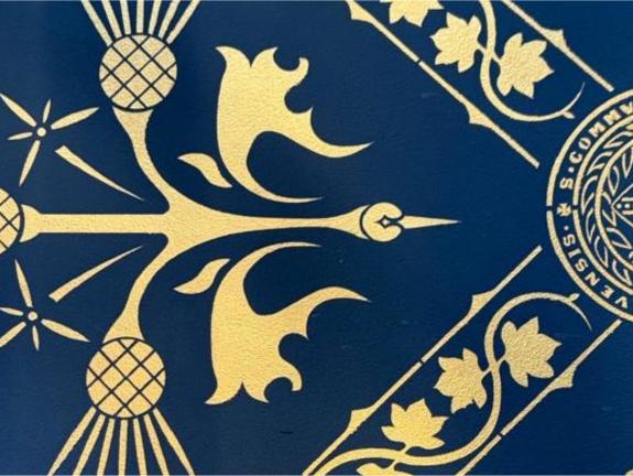 Close up of decorative wall stencilling at Glasgow University in gold on royal blue background