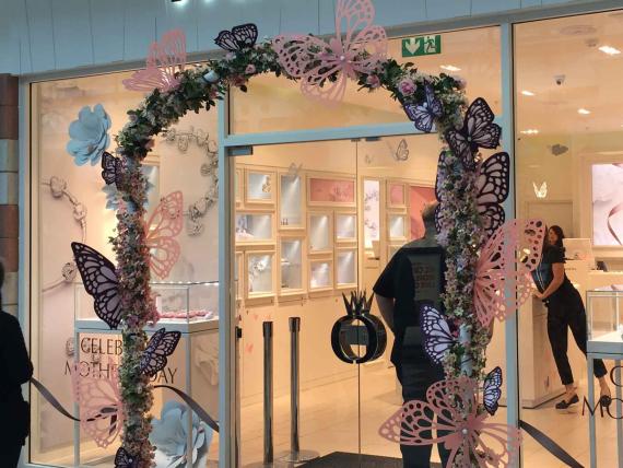 Arched entrance to Pandora store made from laser cut flowers and butterflys
