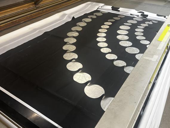 Theatre backdrop design being laser cut into black fabric