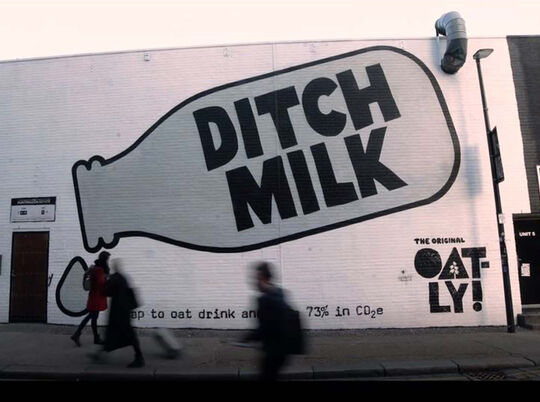 Ditch Milk advert for Oatly sprayed with stencils onto building