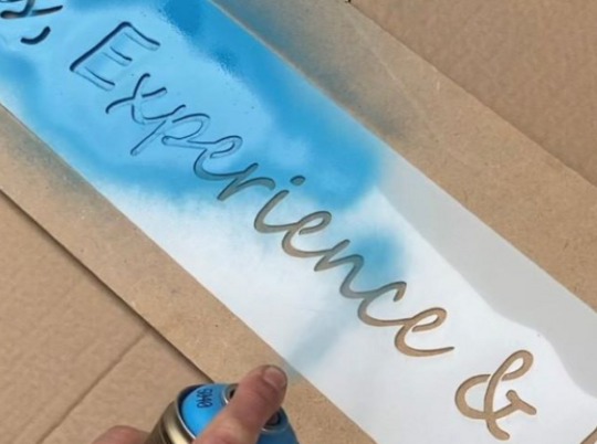 Applying lettering onto MDF using a stencil and blue spray paint