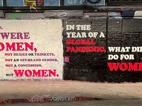 International Women's Day graffiti message in a gritty urban setting