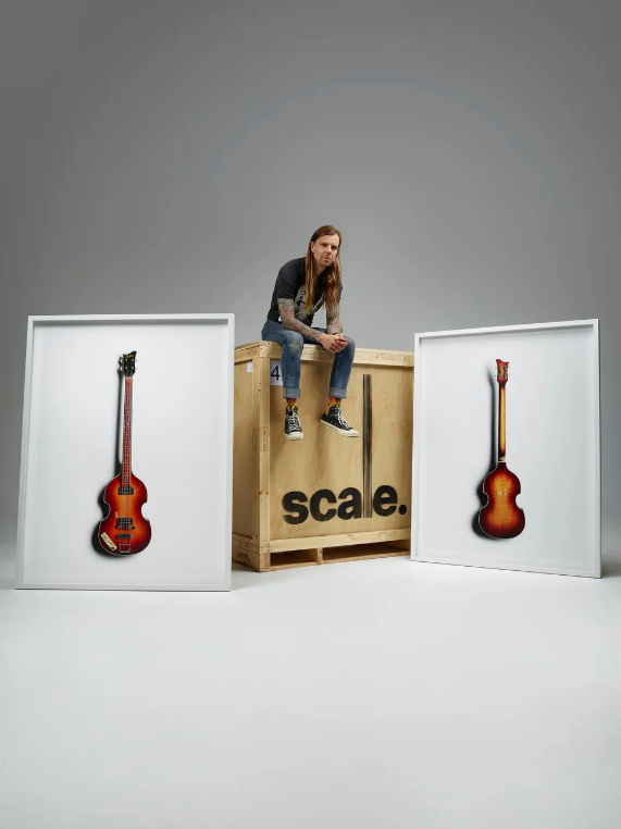 Musician sitting on wooden crate branded with Scale logo